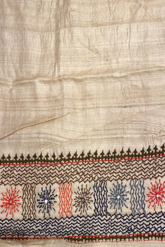 Beige Tussar Lambani and Kutch work saree with stitched blouse, traditional wear by Saarang Sarees featuring intricate hand embroidery.