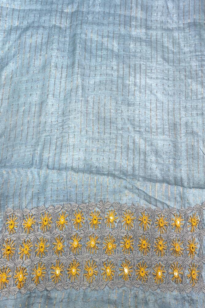 Light blue Tussar Lambani and Kutch work saree with unstitched blouse, traditional wear by Saarang Sarees, detailed embroidery visible.
