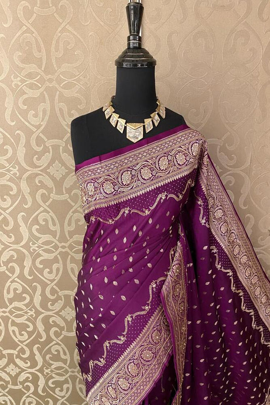 Deep purple Banarasi saree with stone work and traditional design, paired with an unstiched blouse from Saarang Sarees.