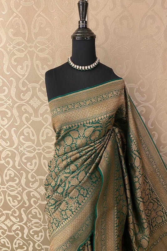 Deep green brocade Kora Banarasi silk saree with intricate gold zari work and matching unstiched blouse from Saarang Sarees.