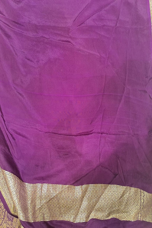 Deep purple brocade crepe khaddi silk saree with intricate patterns, paired with an unstitched blouse, ideal for party wear.