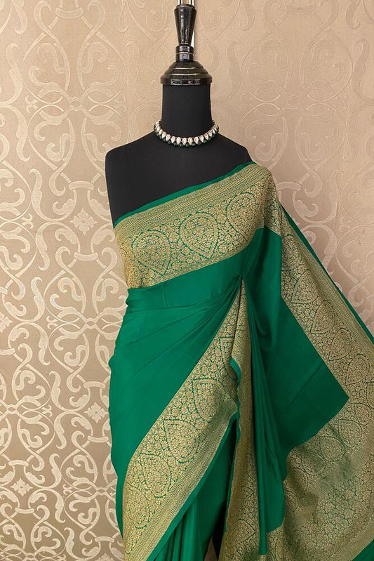 Deep green Mysore crepe silk Banarasi saree with intricate gold zari work, paired with an unstiched blouse for traditional wear.