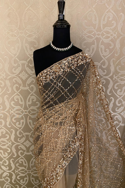 Golden party wear net embroidered saree with matching blouse piece by Saarang Sarees, shown draped and styled for festive occasions.
