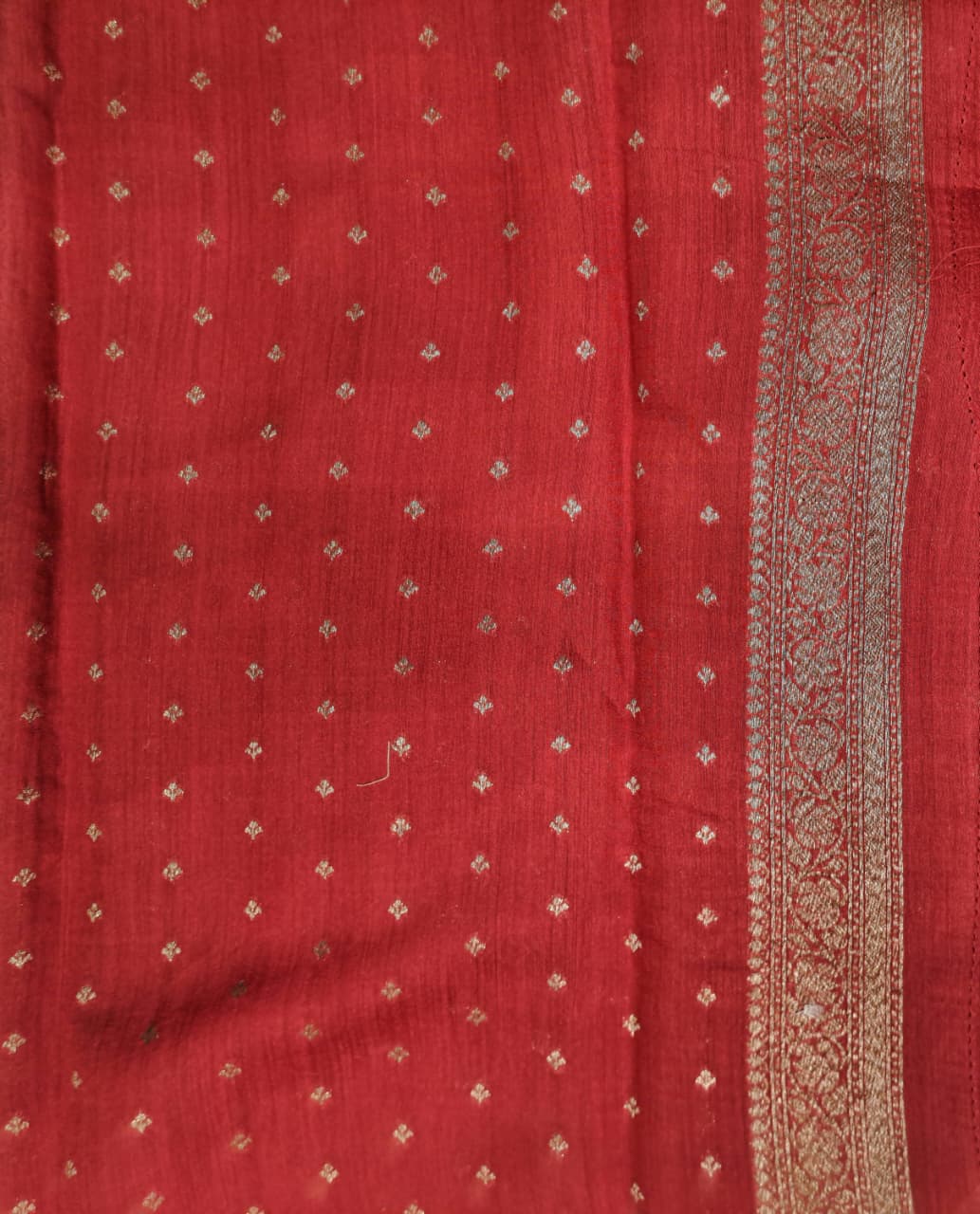 Deep green Munga Banarasi silk saree with intricate gold zari work, paired with an unstiched blouse for traditional wear.