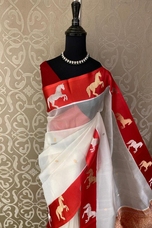 White and red muslin Kora Banarasi silk saree with intricate patterns, paired with an unstitched blouse, traditional wear by Saarang Sarees.