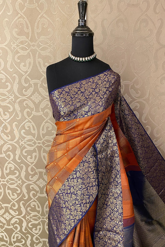 Orange pure Kanjeevaram silk saree with intricate traditional designs and matching unstiched blouse from Saarang Sarees.