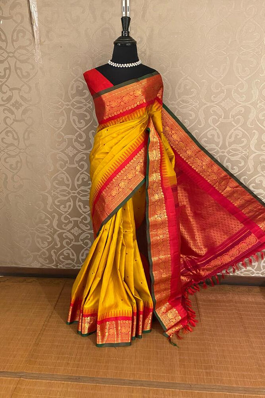 Mustard yellow Gadwal silk saree with intricate traditional design and matching unstiched blouse from Saarang Sarees.