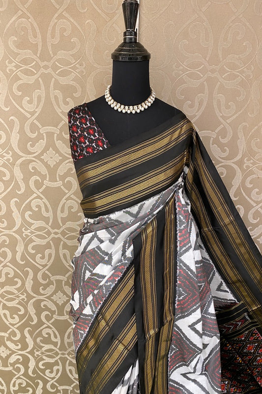 White and black Pochampally Ikat silk saree with multi-color weaving and an unstitched blouse from Saarang Sarees.