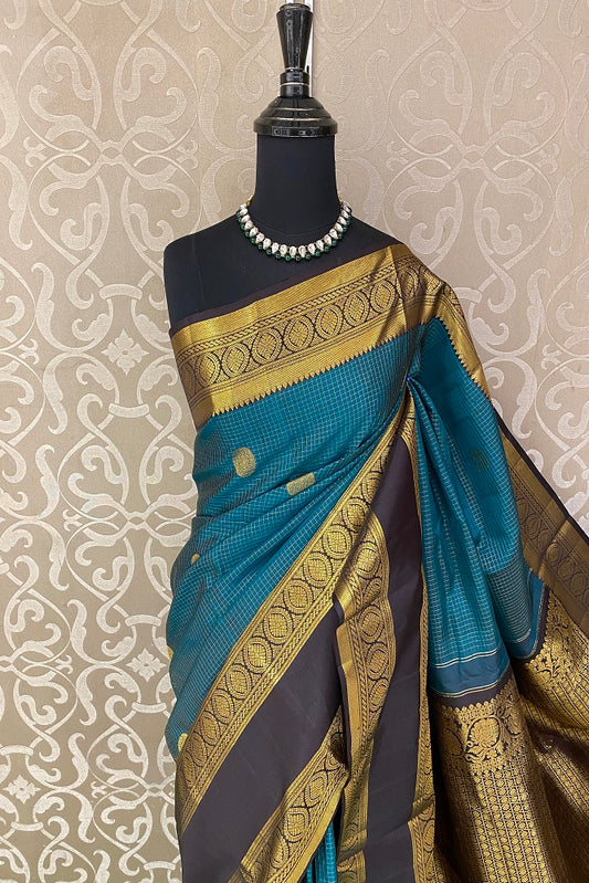 Teal pure Kanjeevaram silk saree with intricate traditional designs and matching unstiched blouse from Saarang Sarees.