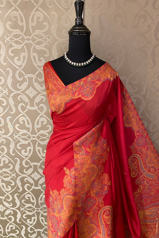 Red pure Kani handloom silk saree with woven blouse, traditional wear displayed on a hanger, showcasing intricate patterns and rich fabric.