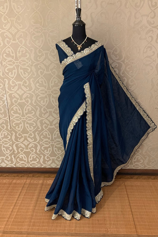 Navy blue organza silk saree with zari border, party wear by Saarang Sarees, draped showcasing elegant traditional style.
