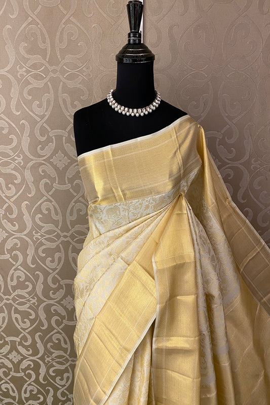 Offwhite gold pure Kanjeevaram silk saree with intricate traditional patterns and matching unstitch blouse from Saarang Sarees.