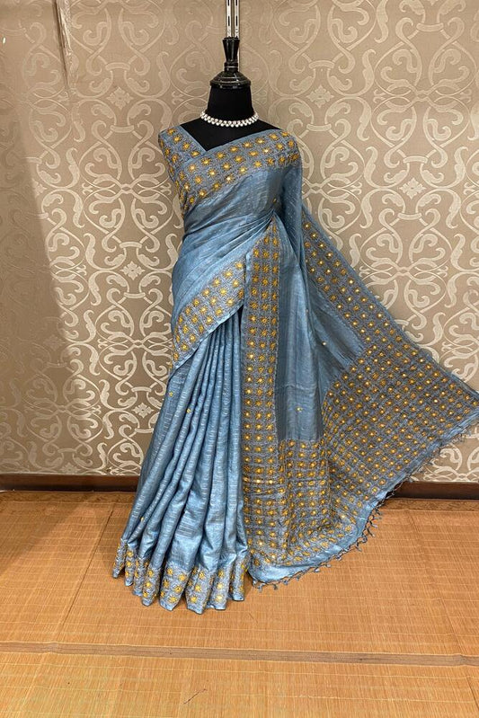 Light blue Tussar Lambani and Kutch work saree from Saarang Sarees with an unstitched blouse, traditional wear with intricate embroidery.