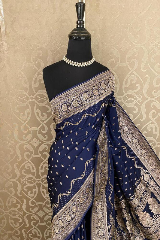 Navy blue Katan Banarasi saree with stone work and intricate traditional patterns, paired with an unstiched blouse from Saarang Sarees.