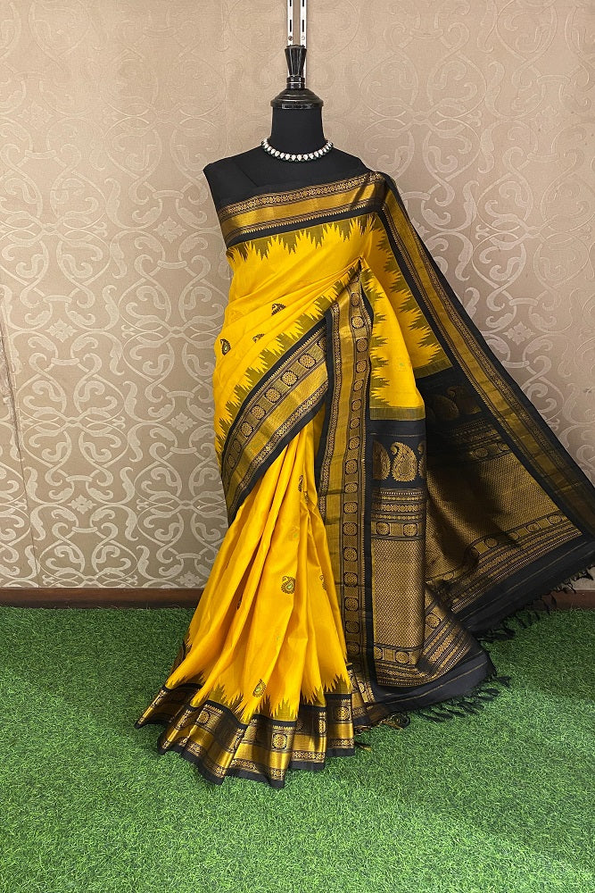 Yellow Gadwal silk saree with traditional border and matching unstitched blouse from Saarang Sarees, displayed on a hanger.