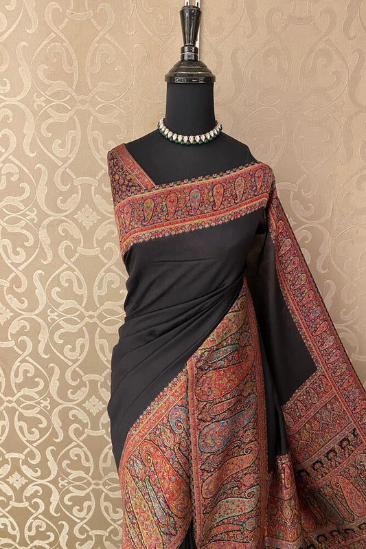 Black pure Kani handloom silk saree with woven blouse, traditional wear by Saarang Sarees, displayed on a hanger.