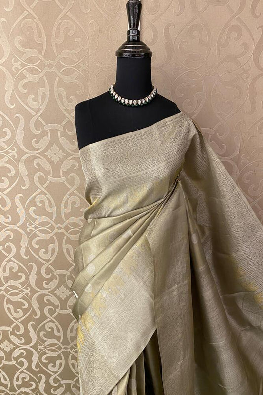 Beige pure Kanjeevaram silk saree from Saarang Sarees with intricate traditional patterns and an unstiched matching blouse.