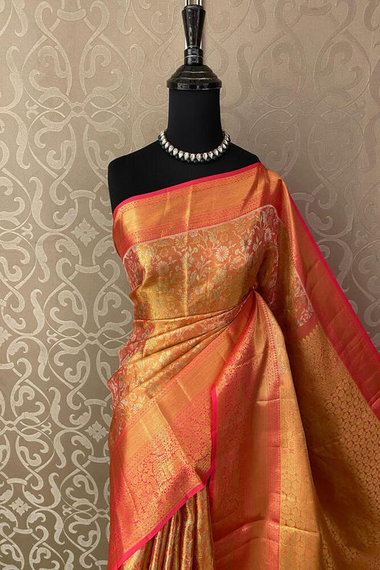 Golden Kanjeevaram silk saree by Saarang Sarees with traditional design and an unstiched blouse, displayed draped for elegant wear.