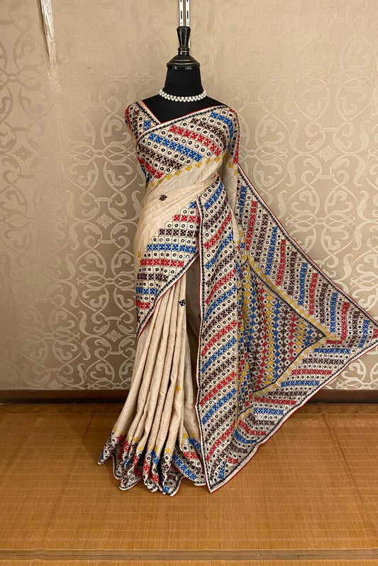 Beige Tussar Lambani and Kutch work saree with stitched blouse, traditional Indian wear from Saarang Sarees, displayed on a mannequin.