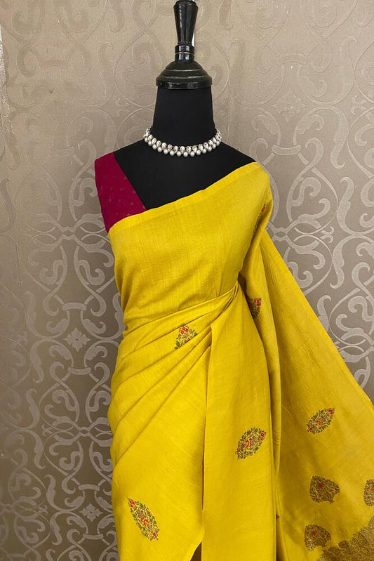 Yellow Munga Banarasi Silk Saree with intricate gold zari patterns, paired with an unstitched blouse for traditional wear.