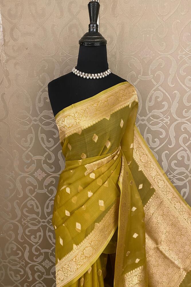 Dusty yellow Kora Banarasi silk saree with handwoven work and unstiched blouse, traditional wear by Saarang Sarees.