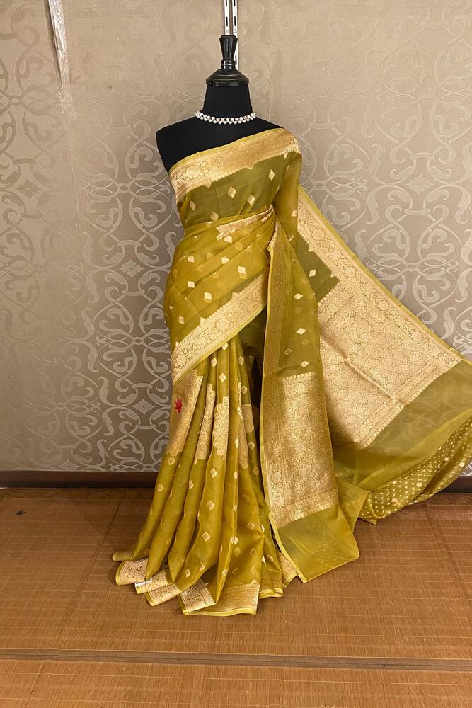 Dusty yellow Kora Banarasi silk saree with handwoven work and unstiched blouse from Saarang Sarees, traditional Indian attire.