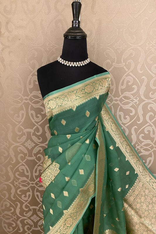 Green Kora Banarasi silk saree with intricate handwoven work and unstiched blouse, traditional wear by Saarang Sarees.