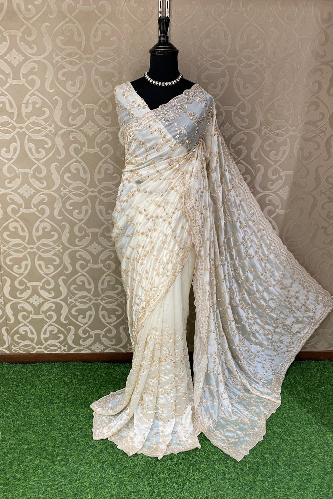 Off-White tissue organza silk saree with embroidery, party wear, featuring an unstiched blouse, displayed on a dress form.