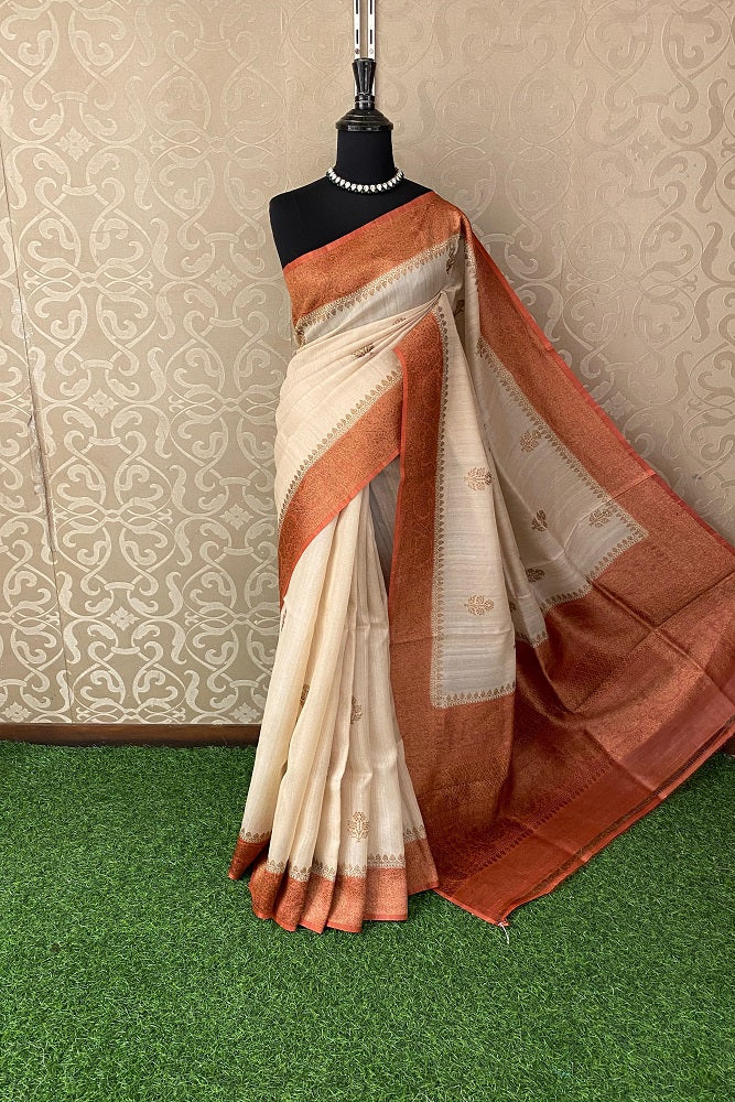 Offwhite Tussar Banarasi silk saree by Saarang Sarees with handwoven motifs and an unstiched blouse, traditional wear.