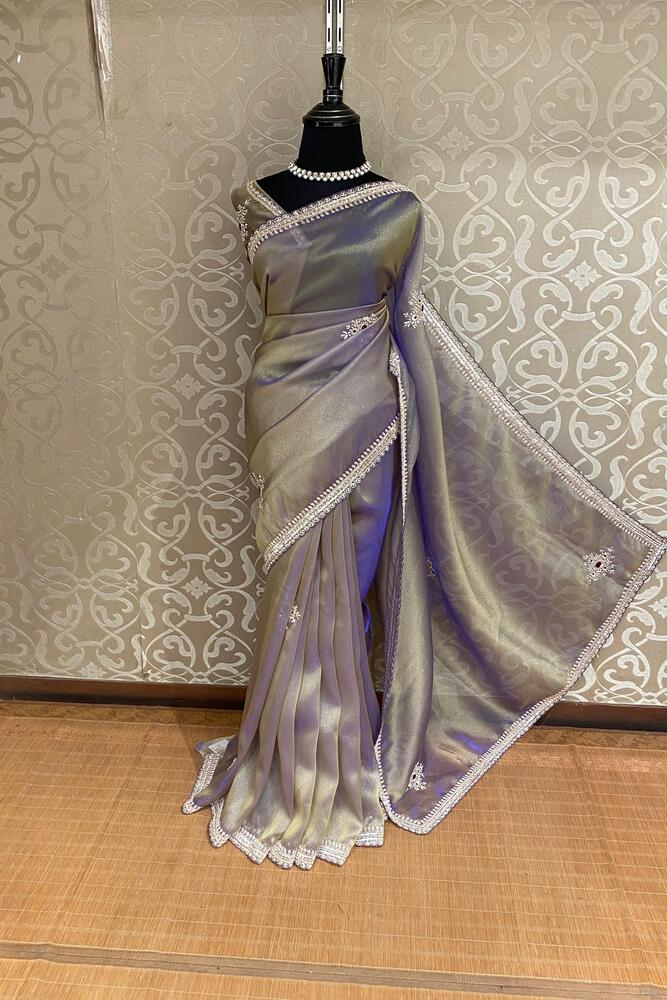 Greyish purple silk saree with embroidery and soft tissue fabric, paired with an unstiched blouse, ideal for party wear by Saarang Sarees.