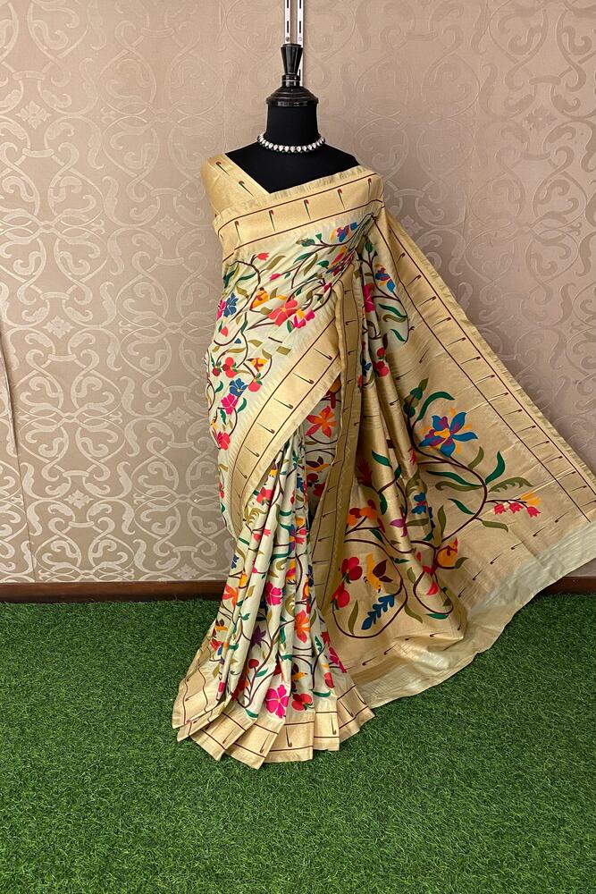 Beige Paithani silk saree with intricate traditional patterns and matching unstiched blouse, displayed on a hanger.