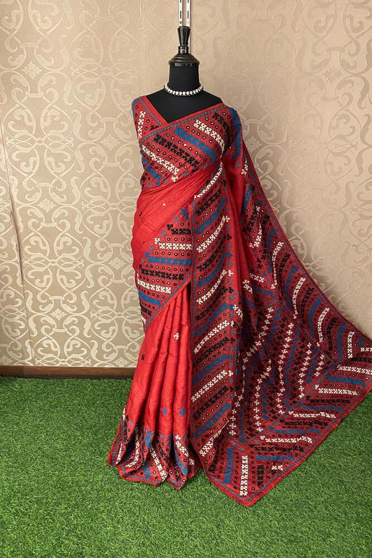 Red Tussar Lambani and Kutch work saree with unstitched blouse, traditional wear by Saarang Sarees featuring vibrant embroidery and fabric.
