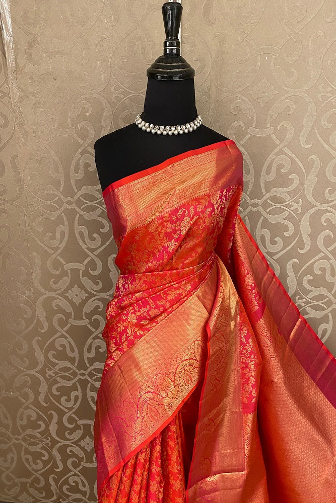 Cherry red pure Kanjeevaram silk saree with traditional gold zari work and an unstiched blouse by Saarang Sarees.