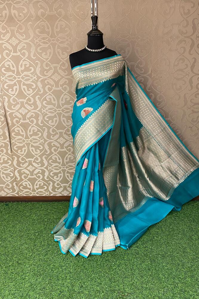 Teal blue Kora Banarasi silk saree with handwoven work and unstiched blouse, traditional wear by Saarang Sarees.