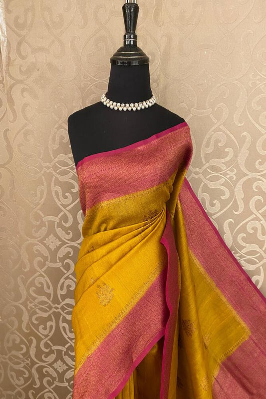 Mustard yellow Tussar Banarasi silk saree with handwoven motifs and an unstiched blouse for traditional wear.
