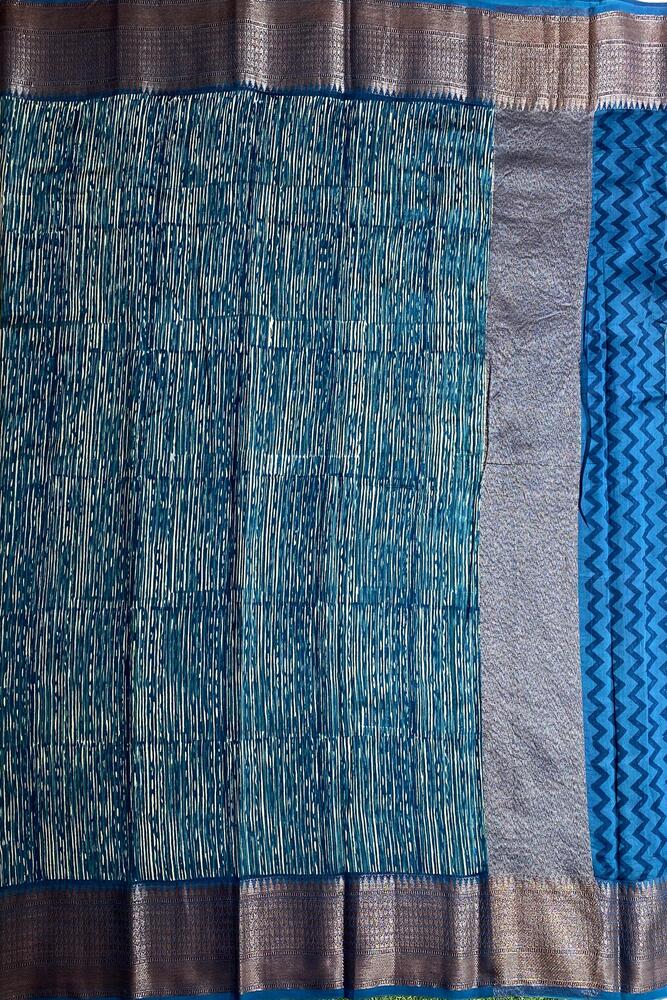 Blue cotton Chanderi saree with traditional design and matching unstiched blouse from Saarang Sarees, showcasing intricate fabric details.