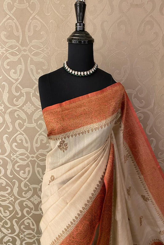 Off-White Tussar Banarasi Silk Saree from Saarang Sarees with hand-woven motifs and an unstitched blouse for traditional wear.
