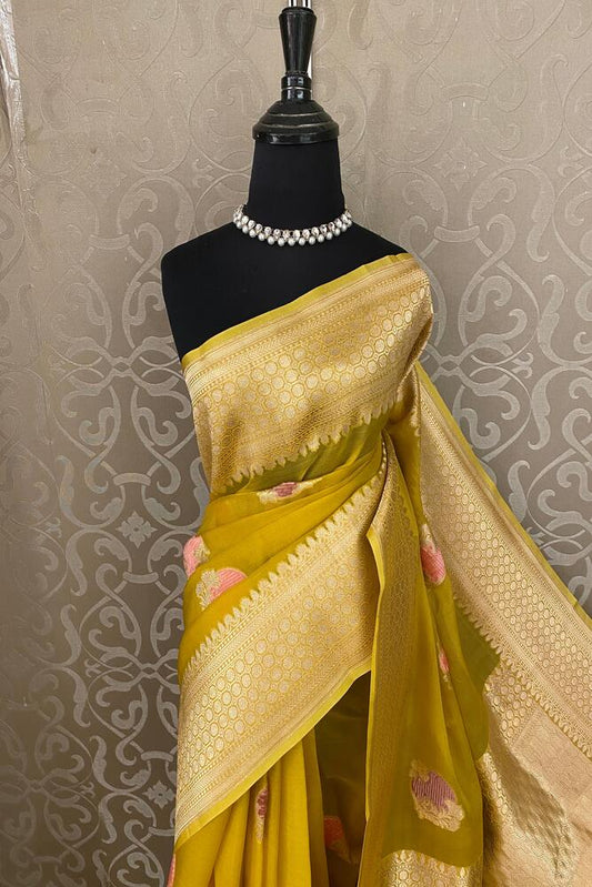 Mustard yellow Kora Banarasi silk saree with intricate handwoven work and an unstiched blouse, traditional wear by Saarang Sarees.