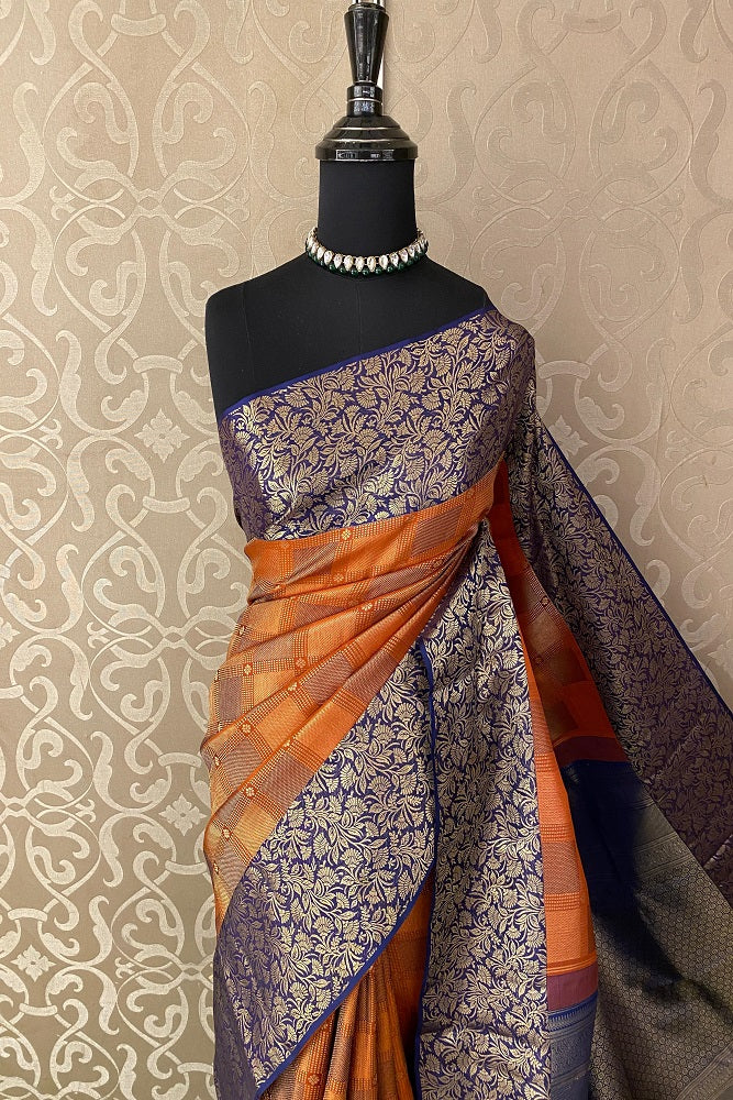 Orange pure Kanjeevaram silk saree with intricate traditional designs and matching unstiched blouse from Saarang Sarees.