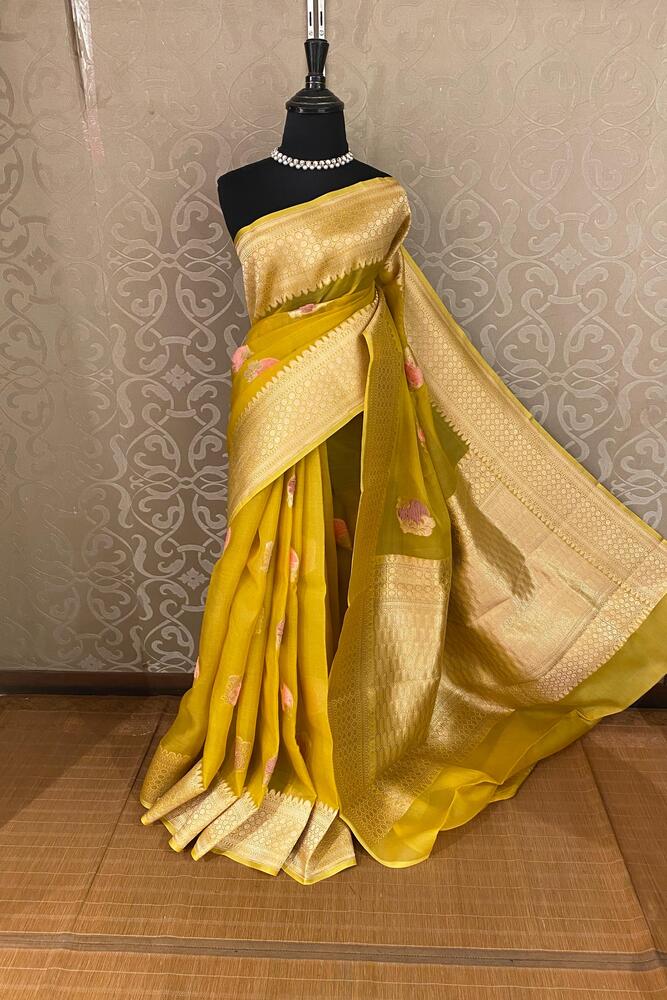 Mustard yellow Kora Banarasi silk saree with handwoven work and unstiched blouse from Saarang Sarees, traditional Indian attire.
