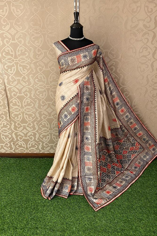 Beige Tussar Lambani and Kutch work saree with stitched blouse, traditional wear from Saarang Sarees, showcasing intricate embroidery.
